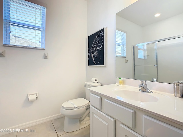 bathroom with tile patterned flooring, vanity, toilet, and walk in shower