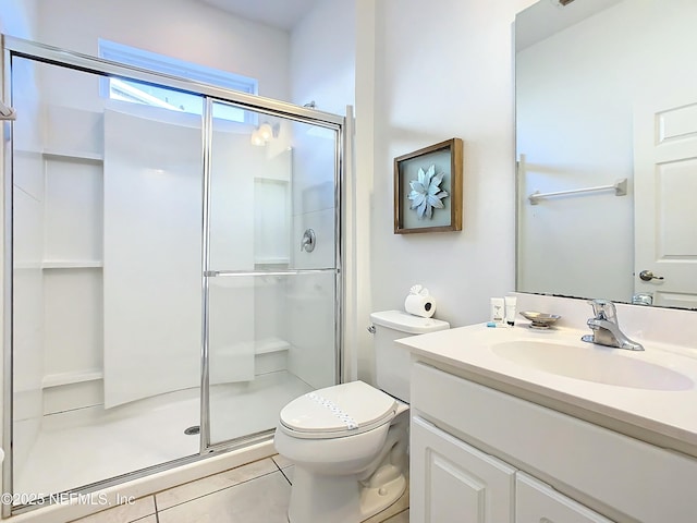 bathroom featuring tile patterned flooring, vanity, toilet, and a shower with shower door