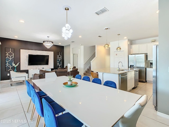 dining room with sink, light tile patterned flooring, and a chandelier