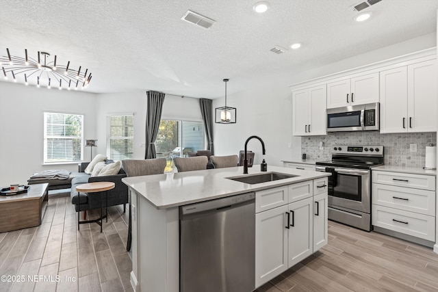 kitchen with sink, stainless steel appliances, and white cabinetry