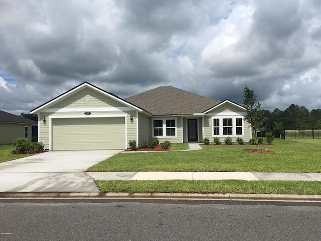 ranch-style house featuring a garage and a front lawn