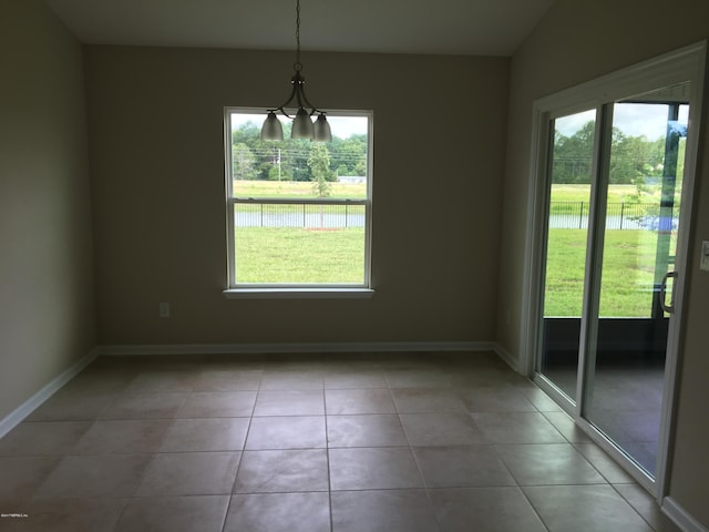 interior space with lofted ceiling, a notable chandelier, and light tile patterned flooring