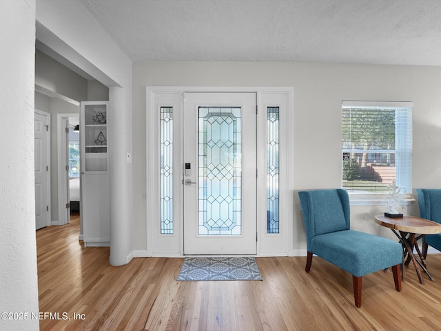 entryway featuring a textured ceiling and light hardwood / wood-style floors