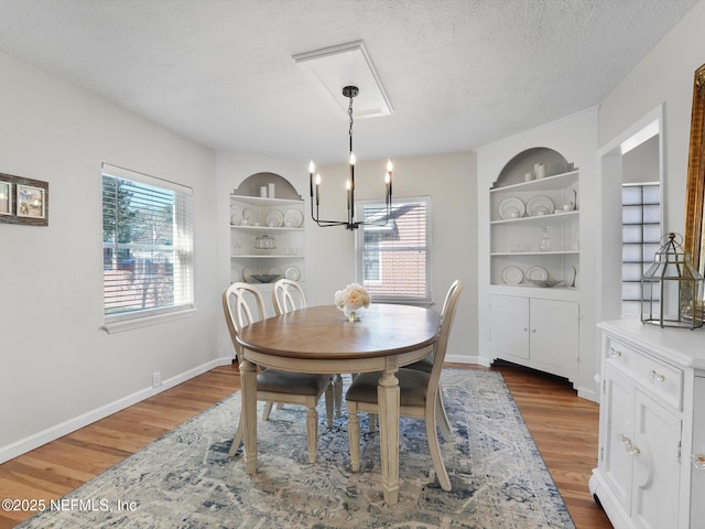 dining area featuring a textured ceiling, dark hardwood / wood-style flooring, and built in features