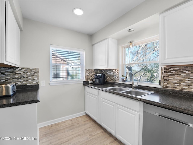 kitchen with sink, white cabinetry, decorative light fixtures, and stainless steel dishwasher