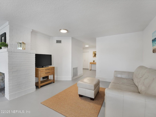 living room featuring a textured ceiling and concrete flooring