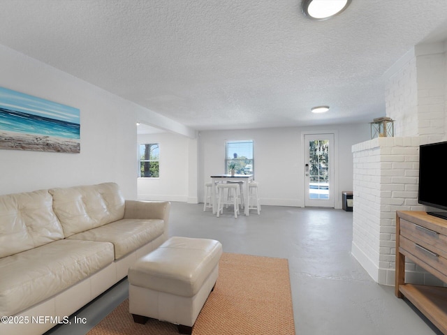 living room with a textured ceiling and concrete flooring