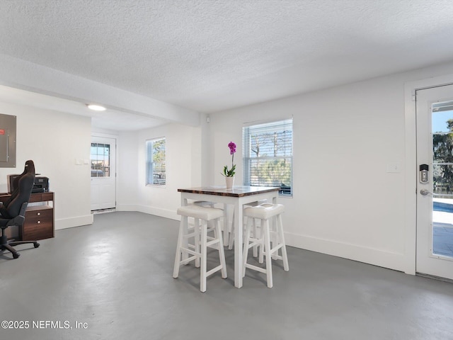 dining space with a textured ceiling and electric panel