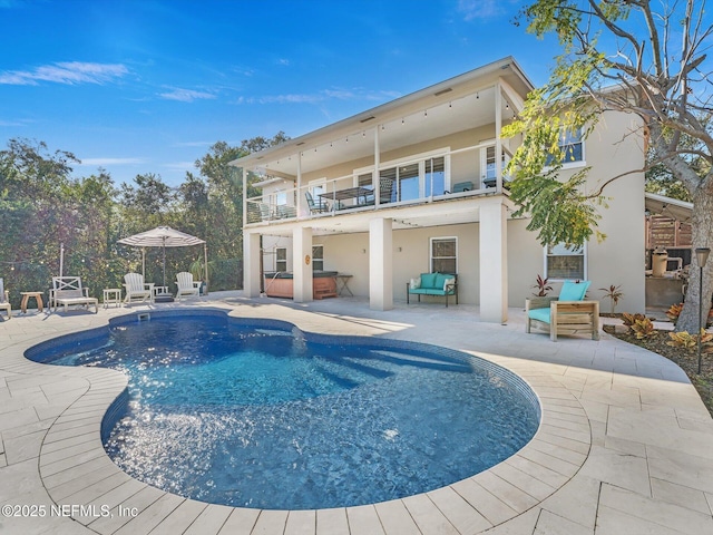 view of swimming pool with a patio and a hot tub