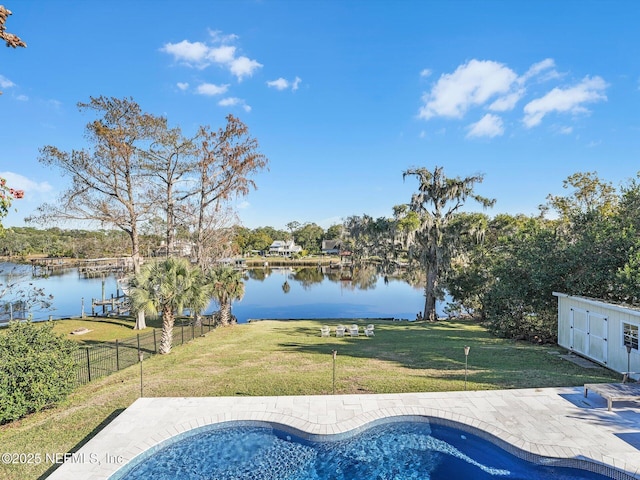 view of pool featuring a water view, a patio area, and a lawn