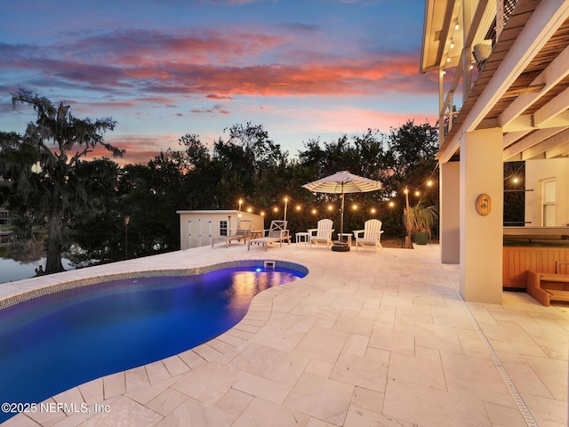 pool at dusk featuring a patio