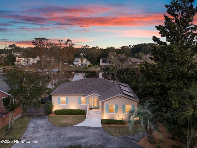 view of front of home with solar panels and a yard