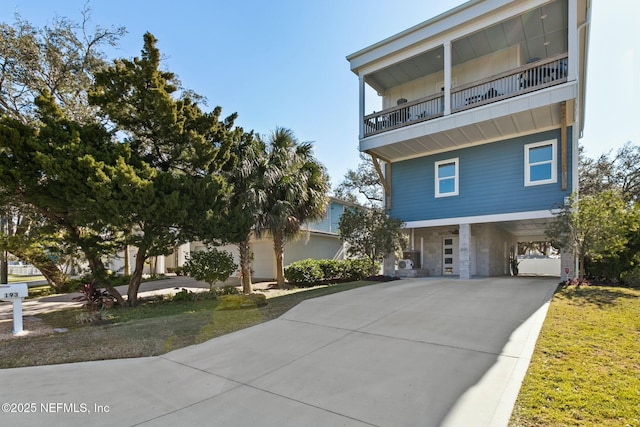 view of front of home featuring a carport, board and batten siding, concrete driveway, and a balcony