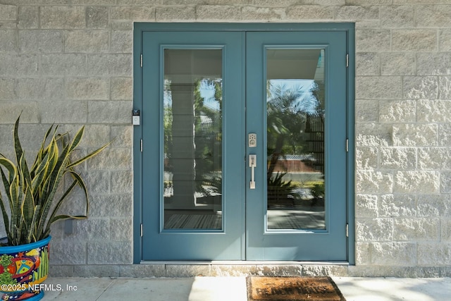 property entrance featuring concrete block siding and french doors