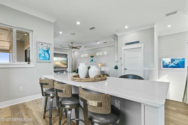 kitchen featuring light stone countertops, visible vents, white cabinetry, and a center island