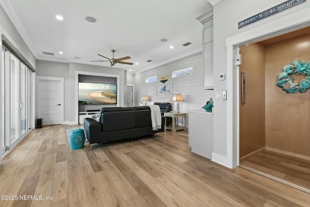 living area with light wood-style floors, recessed lighting, visible vents, and baseboards