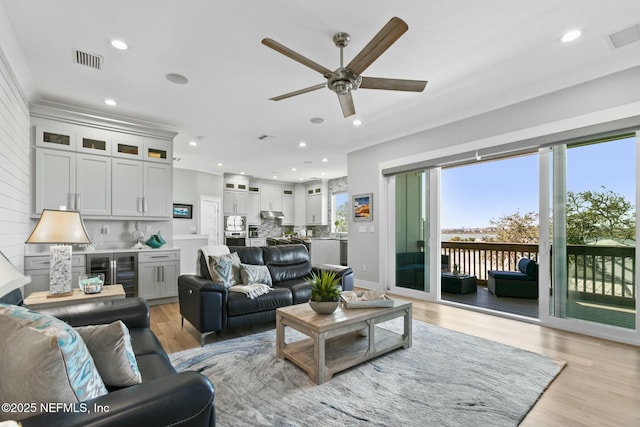 living area with recessed lighting, beverage cooler, visible vents, and light wood-style flooring