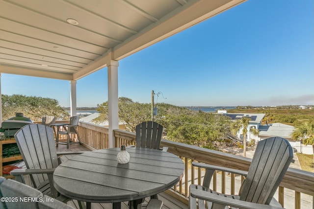 balcony with a water view and area for grilling