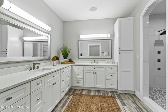 bathroom featuring vanity and tiled shower