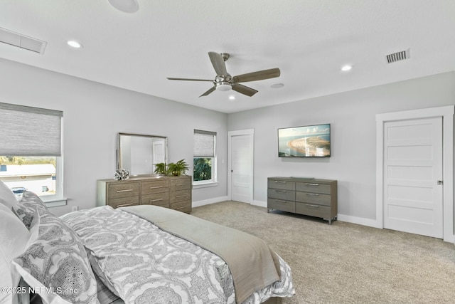 carpeted bedroom with multiple windows and ceiling fan