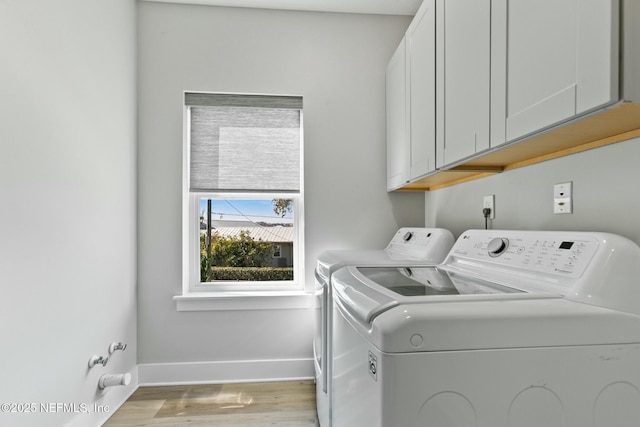 laundry area with cabinets, independent washer and dryer, and light hardwood / wood-style floors