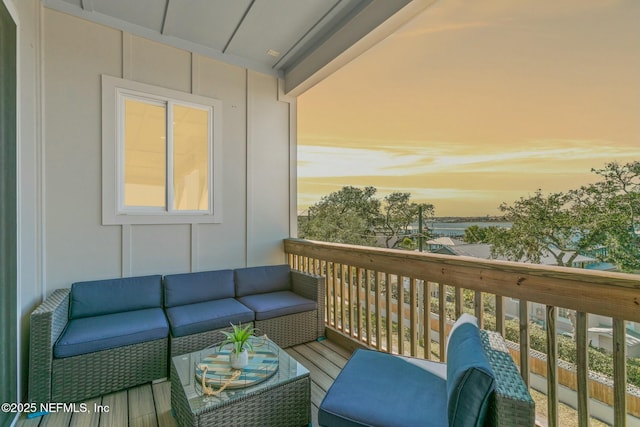 balcony at dusk featuring an outdoor living space