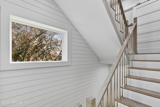 stairway featuring lofted ceiling