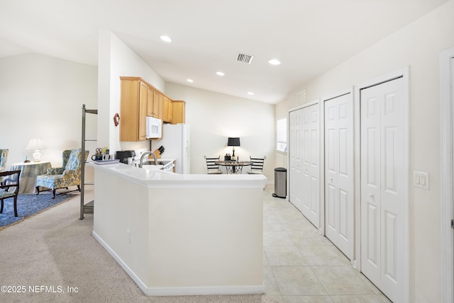 kitchen with light tile patterned flooring, recessed lighting, white appliances, visible vents, and vaulted ceiling