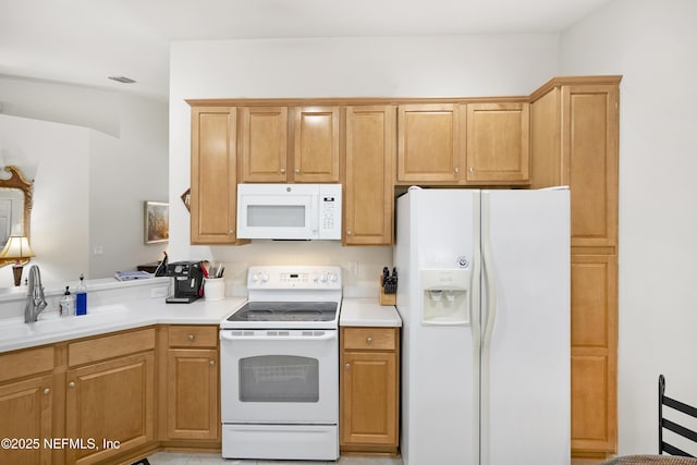 kitchen featuring white appliances, visible vents, light countertops, and a sink