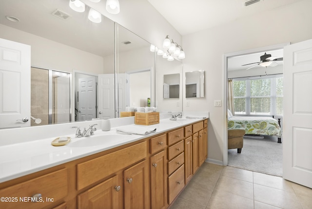 ensuite bathroom with double vanity, tile patterned flooring, a sink, and visible vents