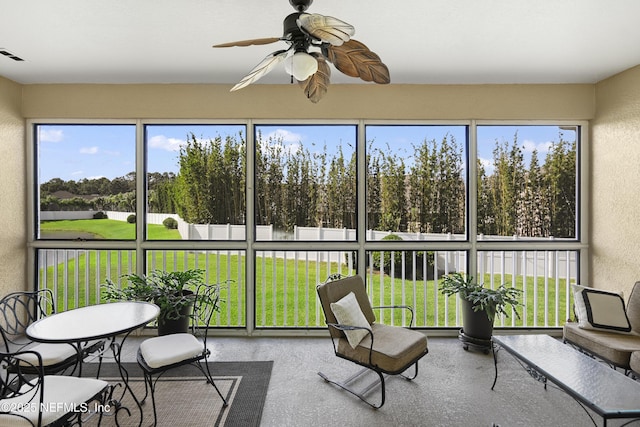 sunroom / solarium featuring plenty of natural light and a ceiling fan