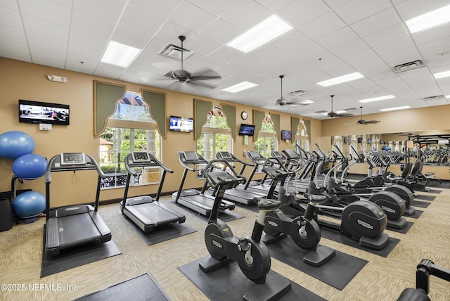 exercise room with a paneled ceiling and visible vents