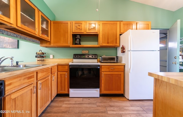 kitchen featuring range with electric stovetop, sink, vaulted ceiling, and white refrigerator