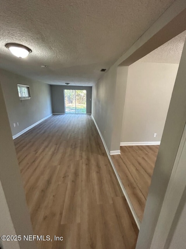 spare room with wood-type flooring and a textured ceiling