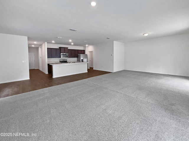 unfurnished living room with dark colored carpet