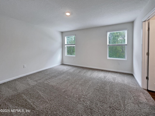 carpeted empty room with a textured ceiling