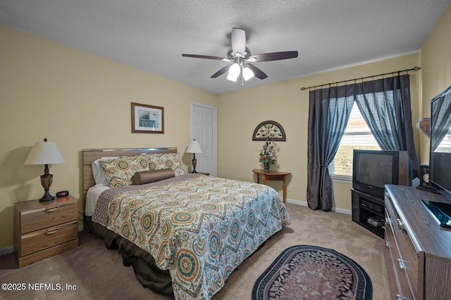 carpeted bedroom featuring ceiling fan and a textured ceiling