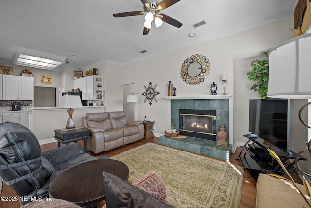 living room with crown molding, light hardwood / wood-style flooring, and a textured ceiling