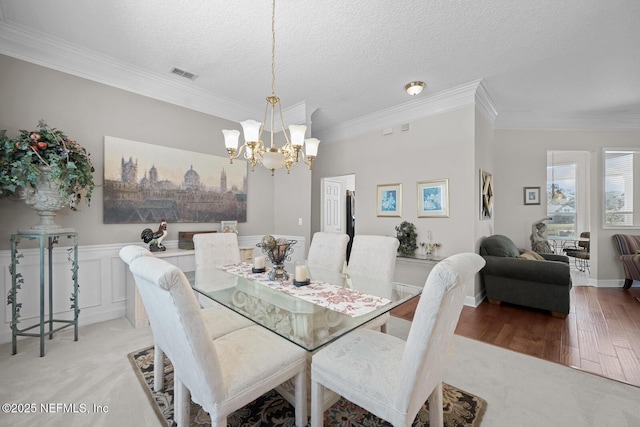 dining area with ornamental molding and a textured ceiling