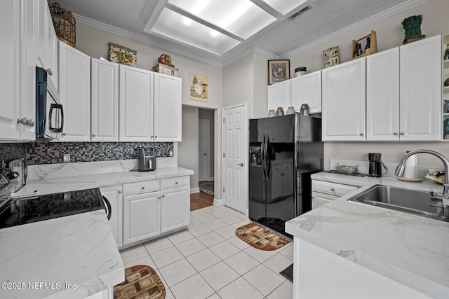 kitchen with sink, range, black fridge, white cabinets, and ornamental molding