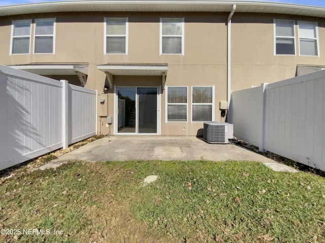 rear view of house featuring a patio, a yard, and central AC