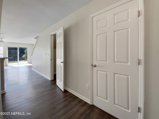 hall with dark hardwood / wood-style floors and a textured ceiling