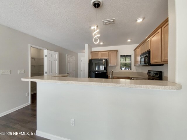 kitchen featuring kitchen peninsula, light brown cabinetry, black appliances, and a textured ceiling