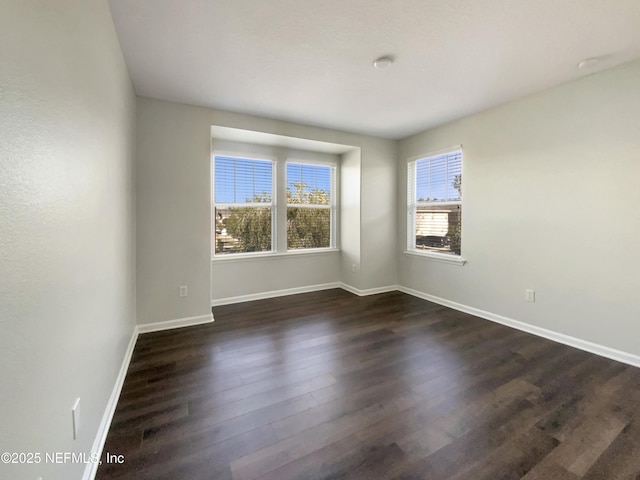 unfurnished room with dark hardwood / wood-style floors