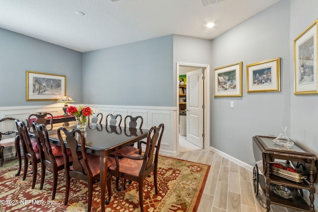 dining room with light hardwood / wood-style flooring and a textured ceiling