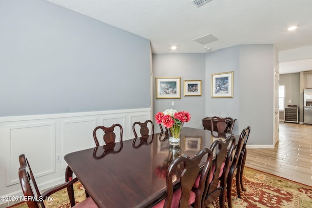 dining room featuring a textured ceiling and light hardwood / wood-style flooring