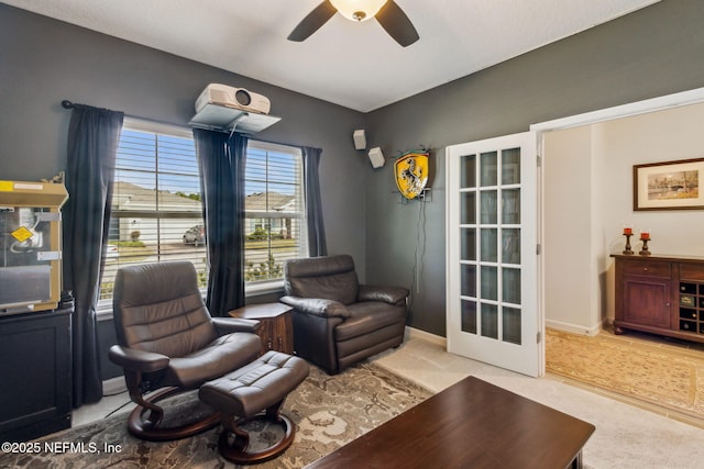 living area with light colored carpet, french doors, and ceiling fan