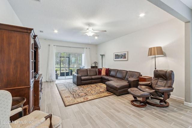 living room with ceiling fan and light wood-type flooring