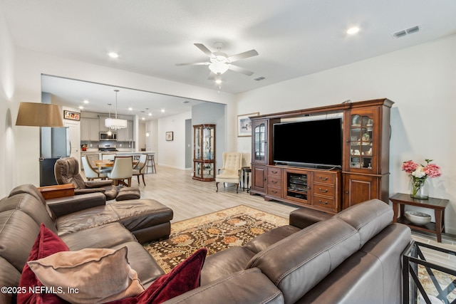 living room featuring light hardwood / wood-style floors and ceiling fan