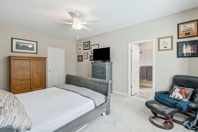 bedroom with ceiling fan, ensuite bath, and light carpet